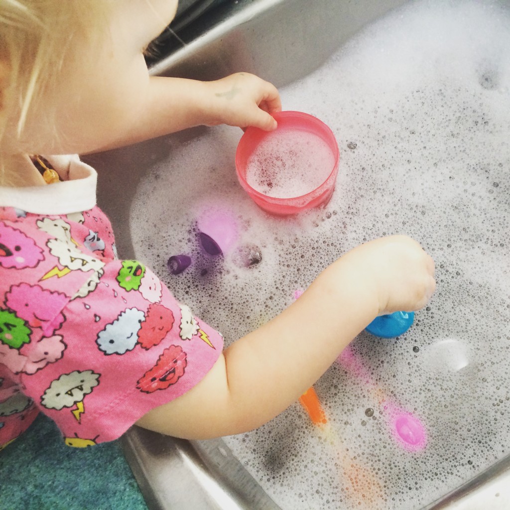 21 months old toddler washing dishes