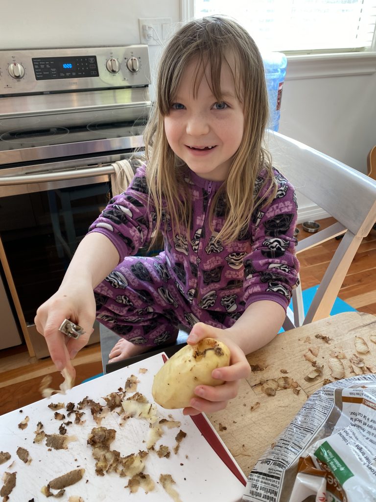 kid peeling potatoes